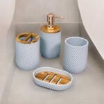 Bathroom soap dispenser set in white and gold with soap dispenser, toothbrush holder, cup and soap holder.