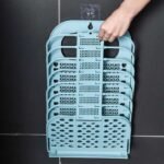 Portable and folded laundry basket hanged on bathroom wall.