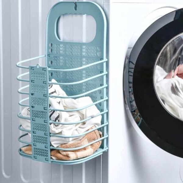Portable laundry basket in cyan holding dirty clothes, hanged on washing machine.