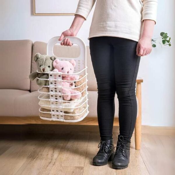 Woman using laundry basket to move towels and teddy bears for cleaning.