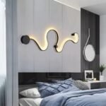 Curved wall light as a statement piece. Modern lamp decorating a bedroom wall.