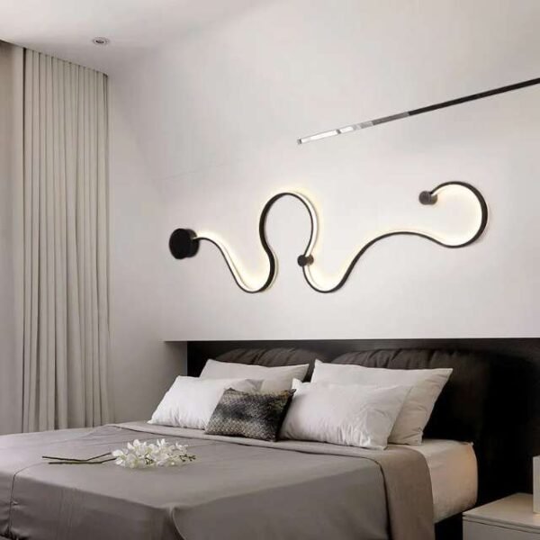 Curved wall light hung on a bedroom wall. Modern wall lamp for stylish illumination.