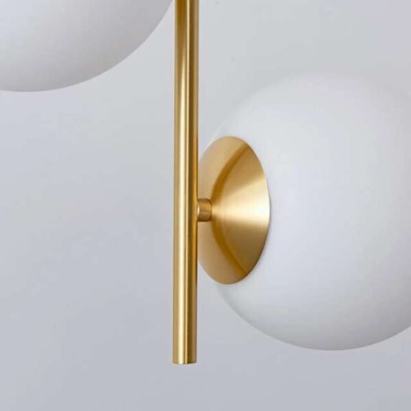 Close up of gold-coated metal design and milky white globes. Rust-resistant ceiling lights with durable construction.