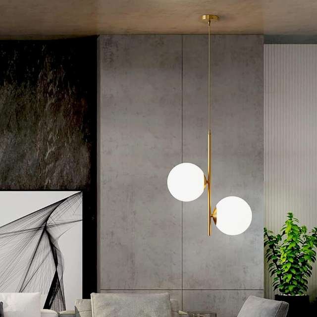 Modern Nordic pendant light illuminating room with warm glow. Hanging ceiling light with 2 white globes for gentle illumination.