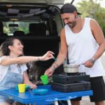 Couple enjoying a meal outdoors with portable gas stove and adjustable heat.