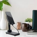 Multifunctional power bank with height-adjustable stand in office setting.