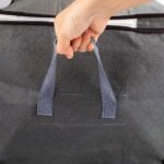 Woman carrying foldable storage bag with handles.