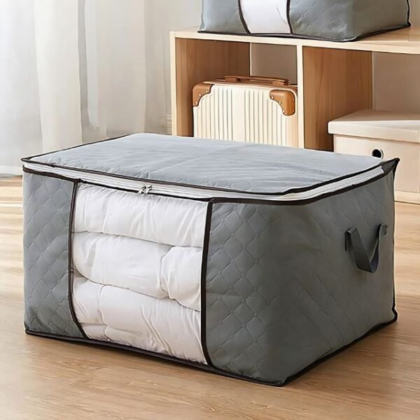 Foldable storage bag in grey with bedding sheets inside.