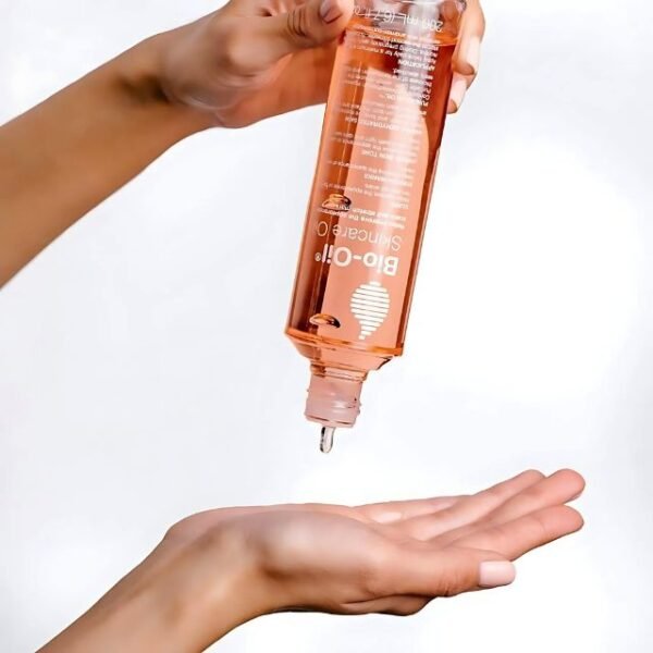 Woman pouring Bio-Oil skincare oil to showcase its smooth, silky texture.