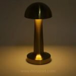 Dimmable mushroom table lamp showing warm light in a dark setting.