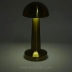 Dimmable mushroom table lamp showing white light in a dark setting.