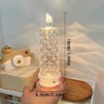 Decorative crystal LED candle lamp in hand, showcasing its compact size and warm glow.