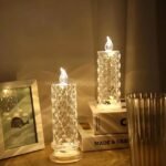 Two crystal-like LED candles on wooden surface with a cozy ambiance, emitting warm light.