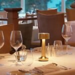 Golden table lamp on dining table creating a warm, cozy glow.