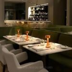 Golden table lamps placed on dining tables with a warm glow.