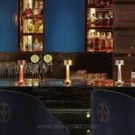 Golden, silver, and bronze minimalist table lamps placed on bar.