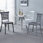 Three minimalist Nordic dining chairs in black, gray, and white arranged in a modern dining room with neutral walls and minimalist decor.