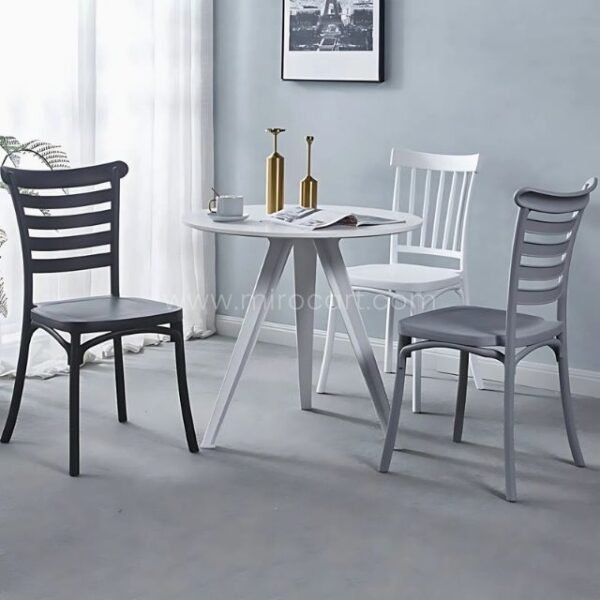 Three minimalist Nordic dining chairs in black, gray, and white arranged in a modern dining room with neutral walls and minimalist decor.