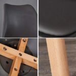Close-up of modern dining chair showing curved design, padded seat, and wooden legs.