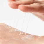 Woman testing the non-oily and smooth texture of COSRX under eye cream.