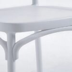 Close-up of a white minimalist Nordic dining chair showcasing smooth seat and modern design details.