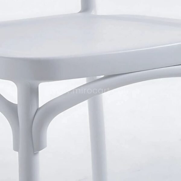 Close-up of a white minimalist Nordic dining chair showcasing smooth seat and modern design details.