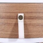 Detailed view of wooden surface with white leather strap detail.