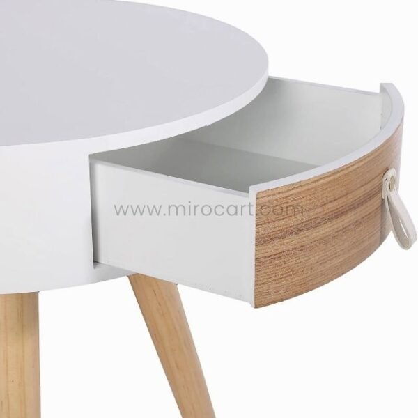 Close-up of a modern bedside table with open wooden drawer.