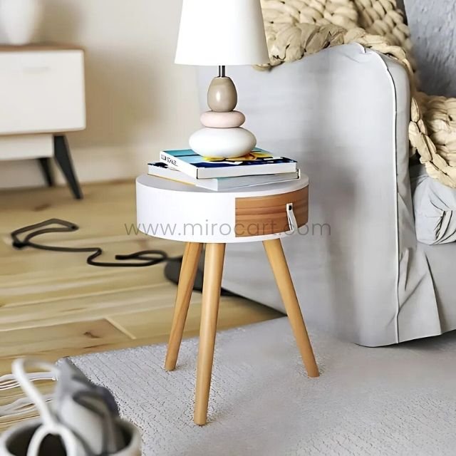 Minimalist side table with books and decorative lamp in living room.