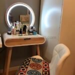 Modern dressing table with wooden top, drawer, and beauty products.