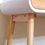 Close-up view of light wooden leg and underside of modern dressing table.