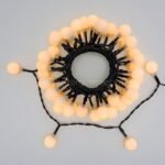 A neatly coiled string of warm white LED lights, ready for easy installation on patios, gardens, or event spaces.