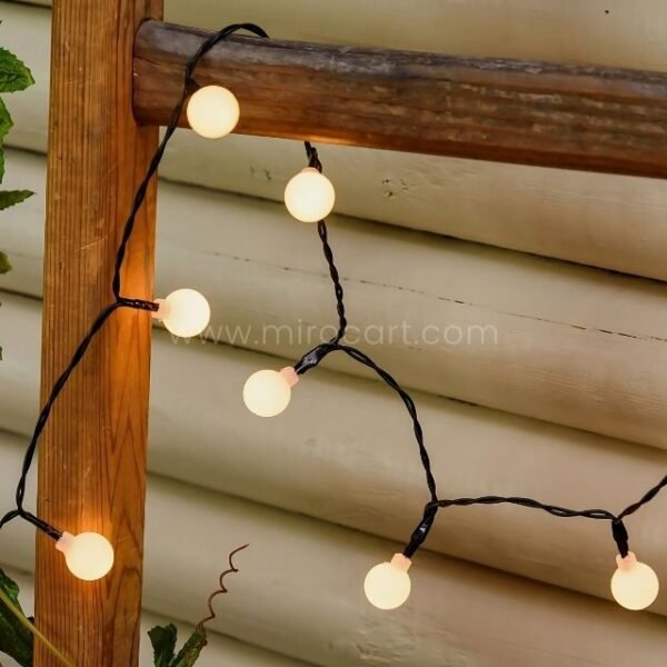 Warm white decorative string lights hanging on wooden panels, casting a soft, inviting glow.