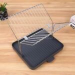 Minimalist black dish rack with metal support rods and integrated handle.