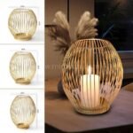 Three gold lantern candle holders in small, medium and large sizes with lit candle.