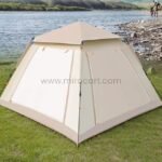Automatic camping tent with closed windows and doors, set up near a rocky shoreline.