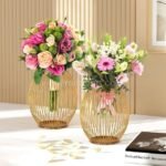 Pink and white floral arrangements in sophisticated gold wire vases.
