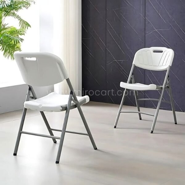 Pair of white folding chairs in a sleek room. Compact and modern for extra seating.