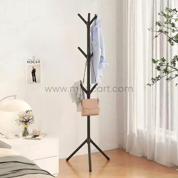 Black coat hanger displaying a shirt and scarf in a bright bedroom.