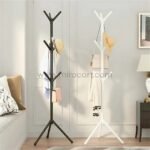 Black and white minimalist tree branch coat hangers holding accessories in a stylish bedroom.