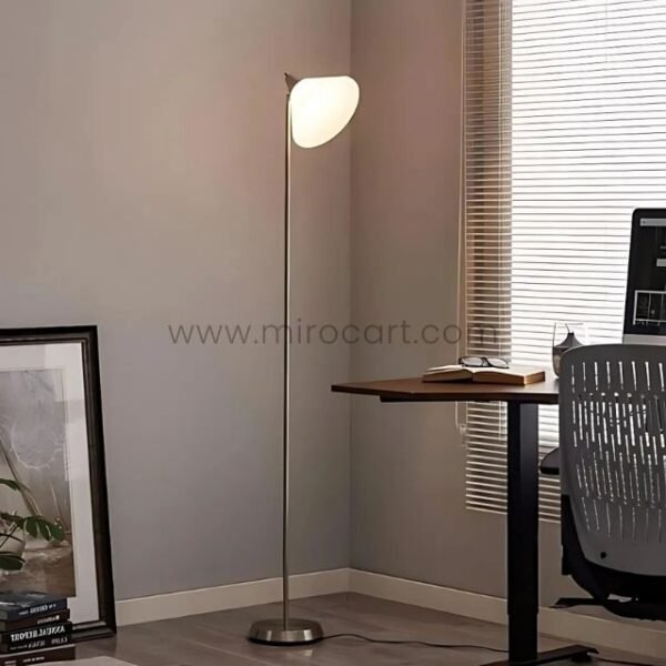 Adesso Swivel Floor Lamp with a polished chrome base, positioned near a desk in a modern office environment.
