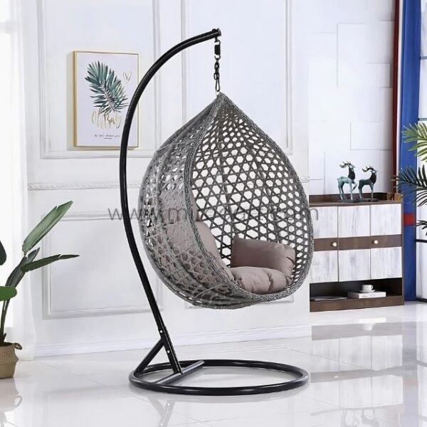 Modern grey rattan hanging egg chair with plush cushion and black steel frame in a cozy living room, featuring 360° swivel for ultimate relaxation