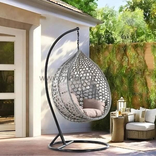 Outdoor hanging egg chair in grey rattan with black stand on sunny patio