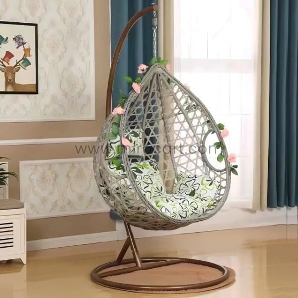 Grey rattan egg chair surrounded by blooming flowers indoors