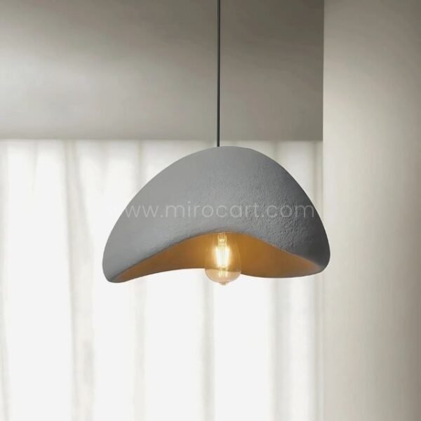 A close-up of the Creative Wabi-Sabi Pendant Lamp, highlighting its textured gray exterior and warm golden interior.