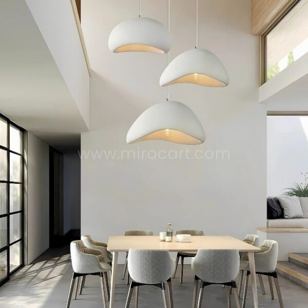 Three Creative Wabi-Sabi Pendant Lamps hang above a sleek dining table, creating a balanced and inviting lighting arrangement.