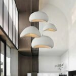 Three Creative Wabi-Sabi Pendant Lamps hang above a sleek kitchen island, creating a warm and inviting focal point.