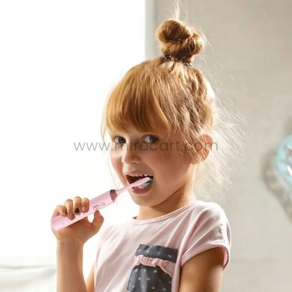 A young girl brushing her teeth with the vibrant pink Green Lion electric toothbrush, showcasing its gentle design and ease of use for children.