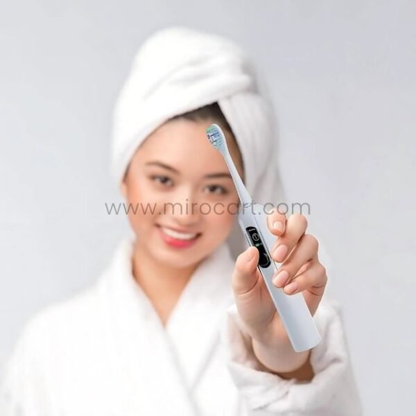 A woman holding the Green Lion Smart Toothbrush demonstrates its ergonomic design and user-friendly interface