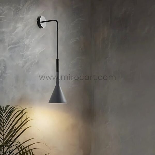 A Nordic Cone Wall-Mounted Lamp casting soft light on a green plant against a textured wall.